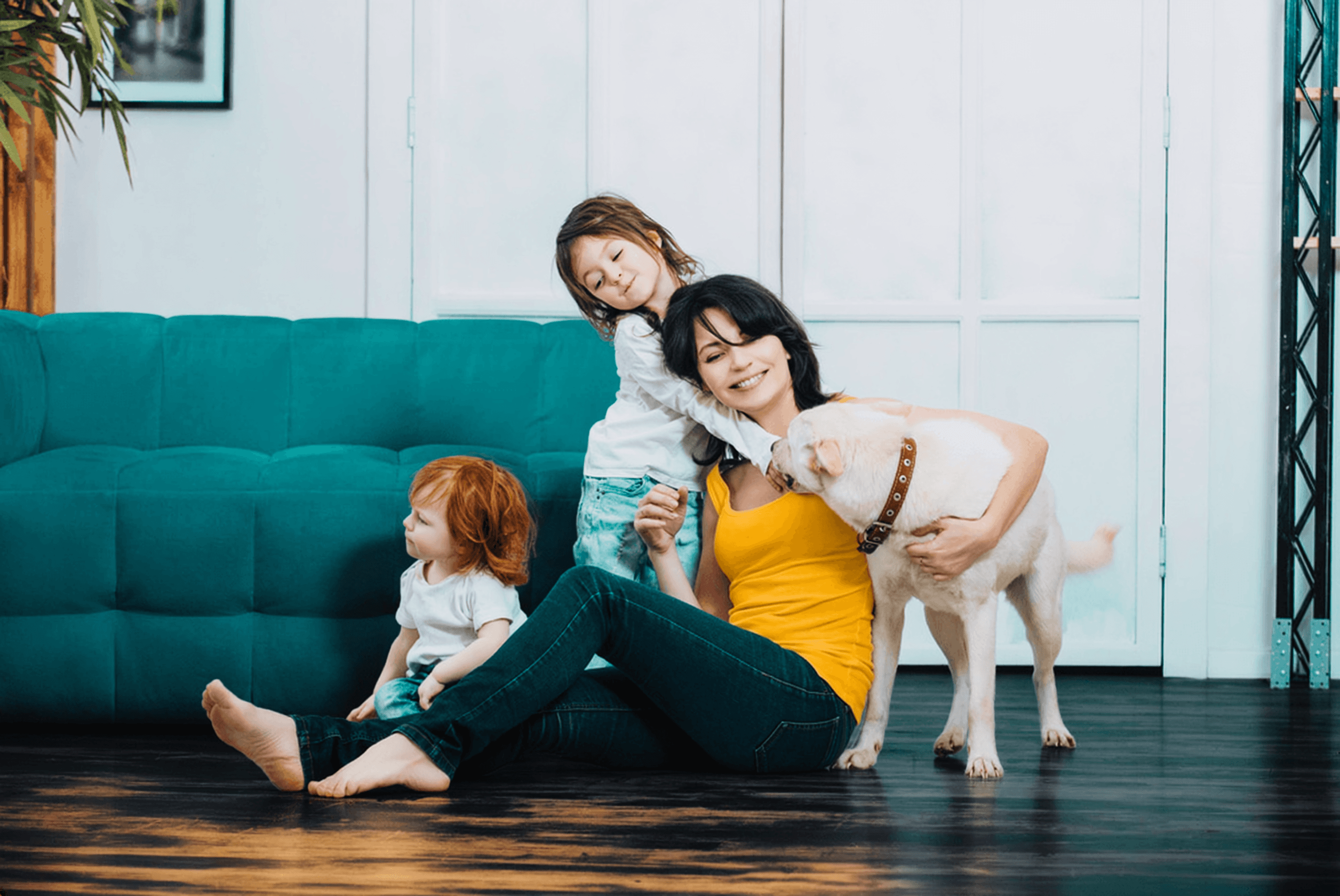 Eine Familie mit ihrem Hund vor der Couch.